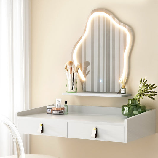 White floating vanity with drawers, LED abstract shaped mirror, makeup brushes, and green vase with plants