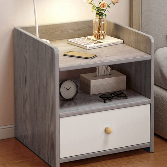 Modern wooden bedside table with drawer, clock, tissue box, eyeglasses, smartphone, and vase with flowers